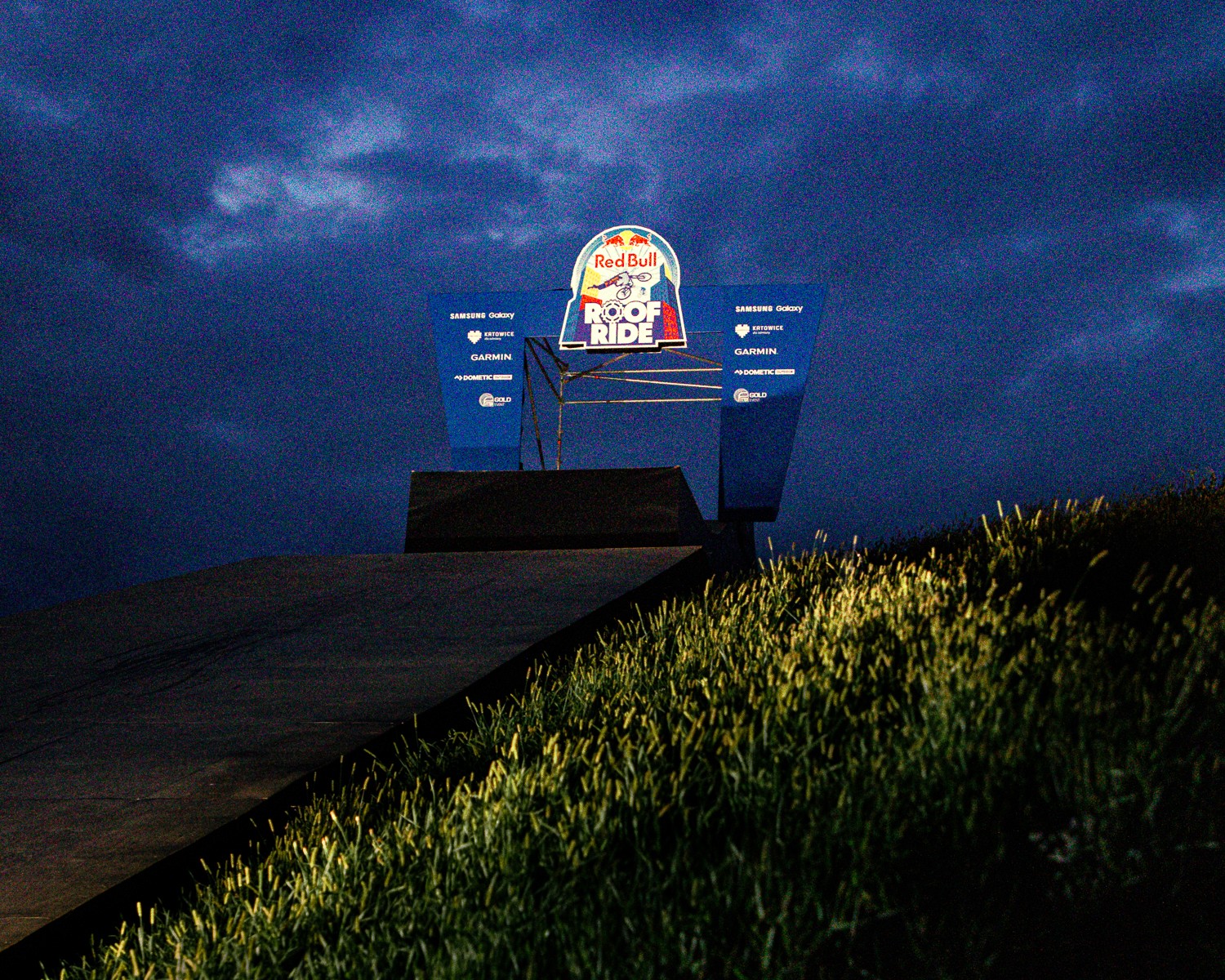Rampe de lancement du Red Bull Roof Ride au crépuscule, éclairée sous un ciel orageux — photographie signée Wave Studio agence de communication à Chambéry.